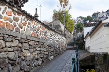 Geleneksel taş duvarlar arasında dar bir ara sokak.