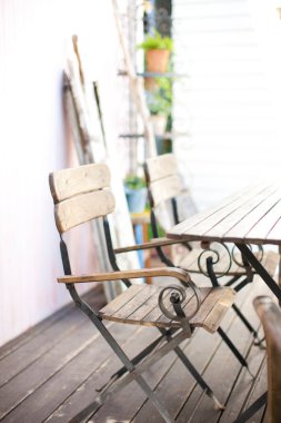 Boş ahşap masa ve terasta sandalyeler 