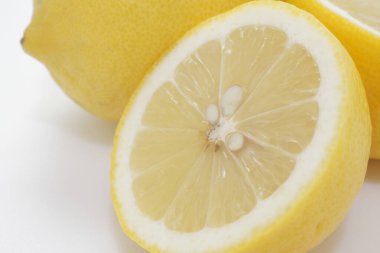 Limon ve yarımlar beyaz arkaplanda limon keser. 