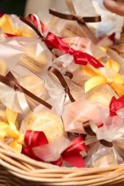 İçinde renkli kurdeleler olan selofana sarılı çeşitli kurabiyeler.