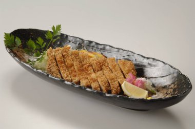 Japon yemekleri tabakta yakın plan görünüyor.