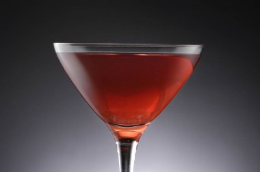 Gri arka planda bardakta gurme kokteylinin yakın plan görüntüsü              