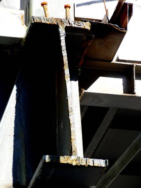 Kapalı çekimde paslı çelik kiriş açık havada büyük endüstriyel yapıyı destekliyor.