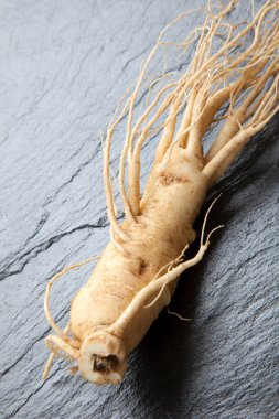 ginseng kökü siyah taş arkaplanda izole edildi