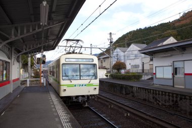 Beyaz tren sessiz açık hava tren istasyonuna yanaşıyor.