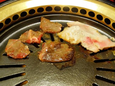 Çeşitli et parçalarını kızartıyorlar.