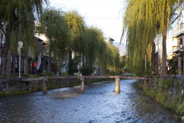 Kanalı ve köprüsü olan küçük Japon kasabasının sokak fotoğrafı.   