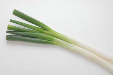 Beyaz arka planda izole edilmiş yeşil soğanlar..