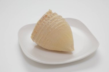 Tek bir bambu kabuğu beyaz tabakta dinleniyor.