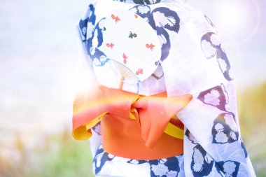 Geleneksel Japon tarzı kimono giyen bir kadının orta kısmı. 