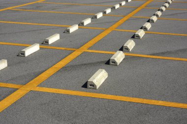 Beyaz blokları ve sarı çizgileri olan boş bir park yeri