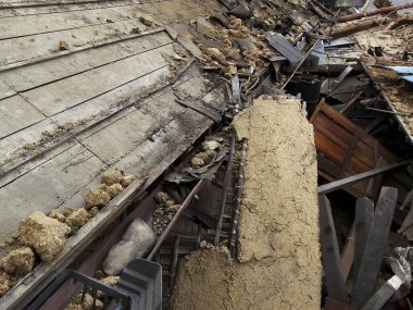 Hasarlı bina enkazı çöktükten sonra yere saçılmış.