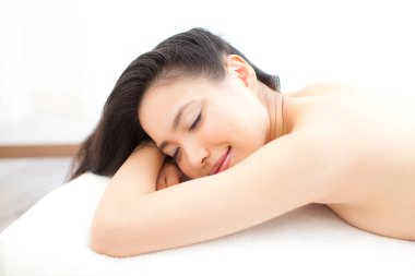 Güzel Asyalı kadın gözleri kapalı yatakta yatıyor.