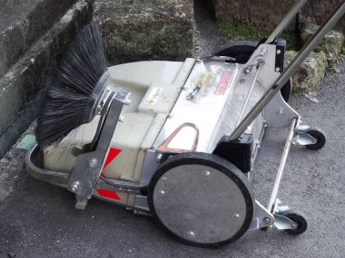 Sokak süpürücüsü beton merdivenlerin yanında dinleniyor.