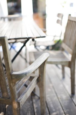 Boş ahşap masa ve terasta sandalyeler 