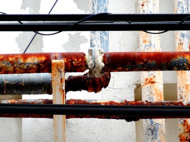 Binadaki eski paslı metal boruların yakın çekim görüntüsü  