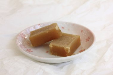 Çiçek tabağında iki kahverengi jelatinli tatlı.