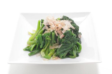 Beyaz bir tabakta yeşil sebzelerin yakın plan fotoğrafı.