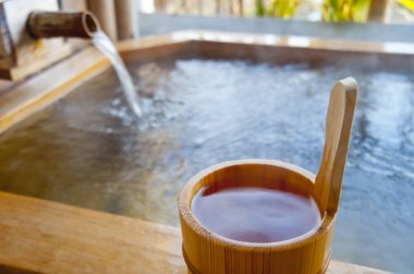 Kaplıcadaki sıcak kaynak suyunun yanında tahta kova.