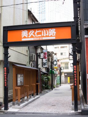 Dar sokak girişinde turuncu Japon tabelası var.