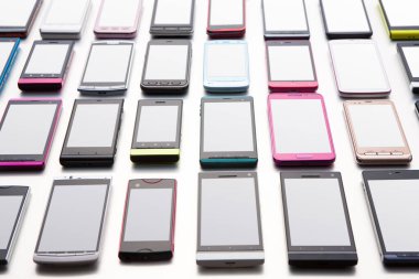 Masanın üzerinde çeşitli renkli akıllı telefon koleksiyonu