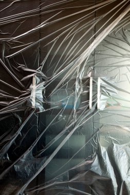 Modern cam kapıları güneş ışığıyla kaplayan plastik çarşaf.