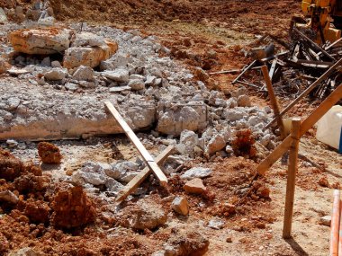 Kırık beton molozları kahverengi inşaat sahasına saçılmış.