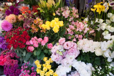 Bir sürü renkli çiçek buketi olan bir çiçekçi.