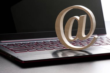 Arka planda e-posta sembolü ve dizüstü bilgisayar klavyesi, kapat