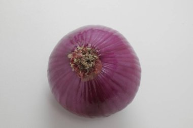Beyaz zemin üzerinde organik mor soğanın yakın plan görüntüsü.      