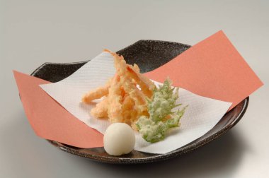 Japon yemekleri tabakta yakın plan görünüyor.