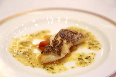 Tabağında sos olan gurme balık yemeği.