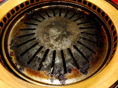 Kirli ızgara tenceresi yanmış kalıntıları ve lekeleri gösteriyor.