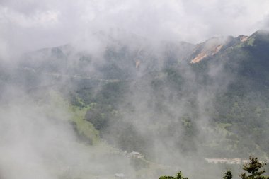 Sisin içinde yeşil ağaçlar olan dağların güzel manzarası  