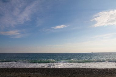 Arkasında dalgalar olan güzel deniz kıyısı.