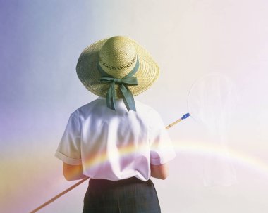 Gökkuşağının altında ağ tutan çocuk