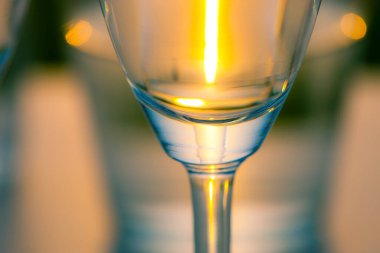 Parlak ışıklı parlak şarap kadehinin yakın plan görüntüsü.