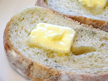 Lezzetli dilimlenmiş ekmeğin erimiş tereyağlı görüntüsünü kapat.