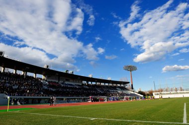 Şehrin futbol stadyumunda arka planda yeşil çimenler var.