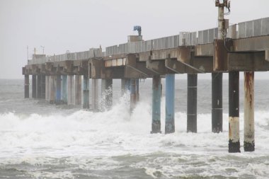 Büyük fırtınalı dalgalar iskeleye çarpar.