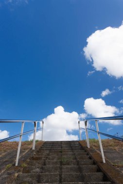 Yukarıya, parlak mavi bir arka plana çıkan merdivenler.