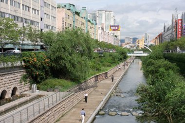 Kentsel nehir yolu boyunca yürüyen insanlar