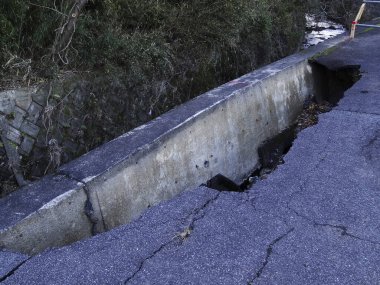 Çatlakları ve asfaltı olan beton bir yol.. 