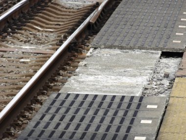 Demir raylar şehir ortamında sessiz, yakın planda.