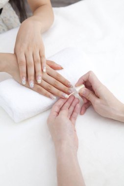 Genç Asyalı kadın güzellik salonunda manikür yapıyor.