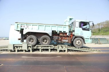 Güneşli bir günde büyük bir çöp kamyonu dışarıda park etmiş.