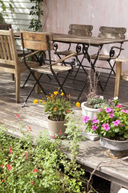 Çiçekli bir bahçede masa ve sandalye.