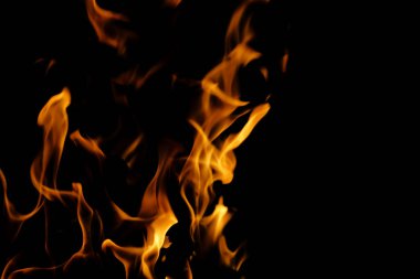 Karanlıkta sarı alevleri olan bir ateş.