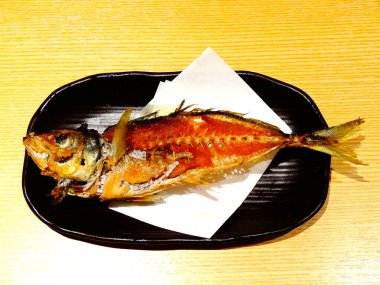 Serving grilled fish on black plate