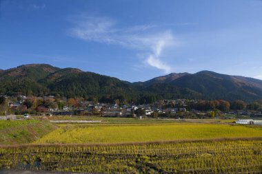 Köyün üstündeki mavi bulutlu gökyüzü Renkli dağlarda, gündüz manzaralı
